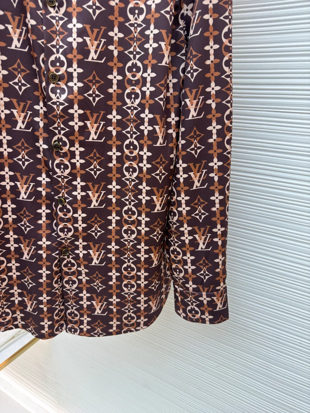 LOUIS VUITTON Overlap pattern printed long-sleeved mulberry silk shirt ●Original version: purchased and developed for 17000 ●Item number: 1682309-A60 ●Fabric: cotton fabric ●Technology: printing production ●Color: pattern ●Version: fitted version ●Weight: about 360 grams ●Size: S-M-L-XL ●Description: This Louis Vuitton all-over printed presbyopic shirt is made of high-count silk blended fabric. It is custom-woven and dyed to ensure the gloss and drape of the fabric while achieving precise coloring of the presbyopic pattern, with a color fastness of level five or above. The pattern printing uses digital direct printing combined with screen overprinting technology to accurately splice classic Monogram elements and geometric plaids. The alignment error of each LV logo and pattern is controlled within 0.5mm. The shirt pieces are laser cut and shaped, with no burrs on the edges and precise dimensions; the placket is made with hand-stitching technology, and the buttons are custom-made metal presbyopia buttons that fit perfectly with the fabric pattern. The double-needle hemming process on the shoulders and side seams improves wearability, and the collar has built-in elastic strips to prevent deformation after long-term wear. The overall stitch length is controlled at 8 stitches per centimeter, and the stitching is even and smooth, perfectly presenting the brand's high-end clothing technology standards. The overall wiring is straight and delicate, the fabric is comfortable and soft, and the color is consistent without color difference. It can be matched with the same style to create a fashionable look and control various occasions. Customized accessories, complete with three standards, same style for men and women!